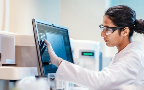 A person in a hazardous materials area looking at a computer screen.