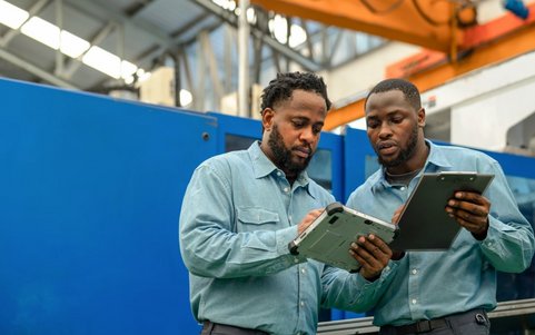 Two occupational safety professionals holding a tablet.