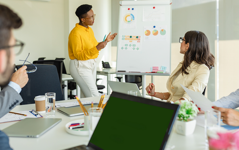 Three people standing in front of a flipchart and discussing
